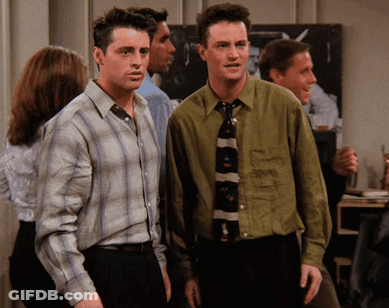 Two Men Standing Next To Each Other In A Room GIF