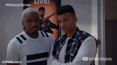 Two Men Standing Next To Each Other In Front Of A Poster That Says Live On It GIF