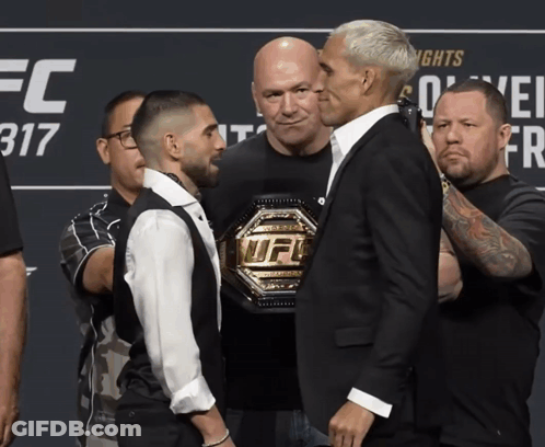 Two Men Standing Next To Each Other In Front Of A Sign That Says Ufc 317 GIF