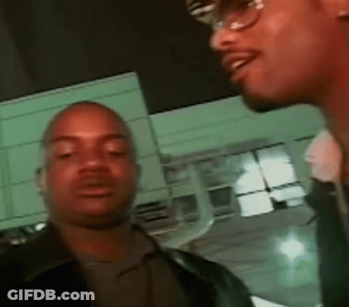 Two Men Standing Next To Each Other In Front Of Building GIF
