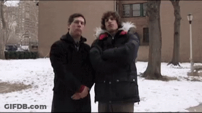 Two Men Standing Next To Each Other In The Snow . GIF