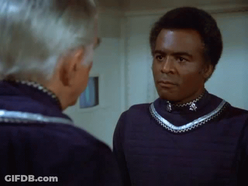 Two Men Standing Next To Each Other Looking At Each Other GIF