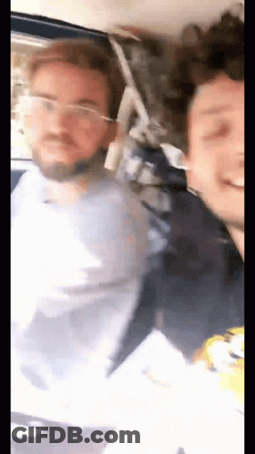 Two Men Standing Next To Each Other On Bus One Wearing Glasses GIF