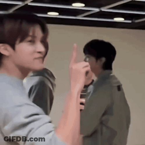 Two Men Standing Next To Each Other One Giving Middle Finger GIF