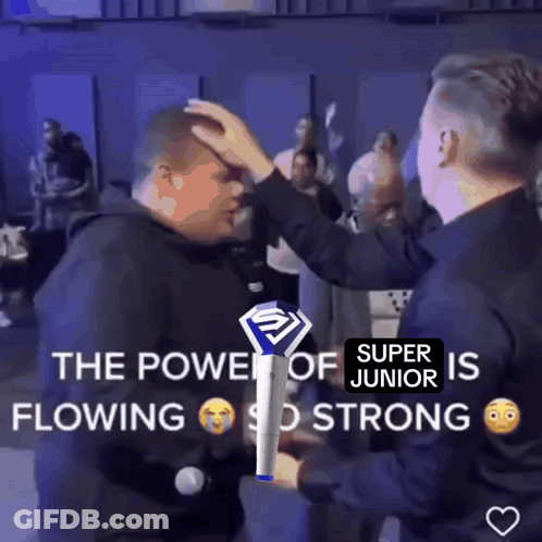 Two Men Standing Next To Each Other One Holding Super Junior Stick GIF