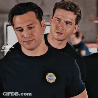 Two Men Standing Next To Each Other One In Firefighter Shirt GIF