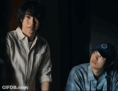 Two Men Standing Next To Each Other One Wearing A Blue Hat With A Badge On It GIF