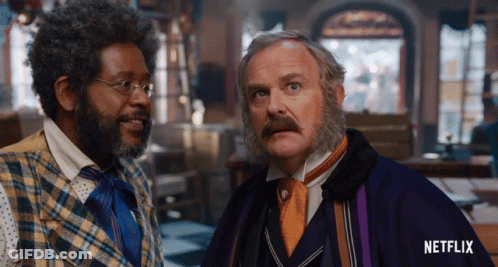 Two Men Standing Next To Each Other With A Netflix Logo On The Bottom Right GIF