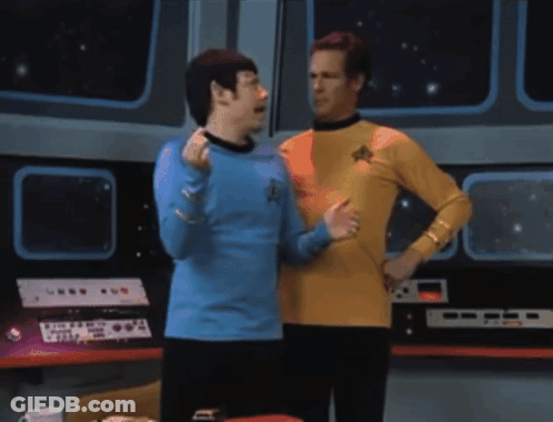 Two Men Standing Next To Each Other With One Wearing A Blue Shirt With A Star Trek Logo On It GIF