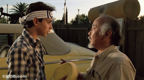 Two Men Standing Next To Each Other With One Wearing A Headband That Says Karate GIF