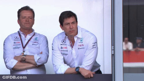 Two Men Standing Next To Each Other With One Wearing A Shirt That Says Ineos On It GIF