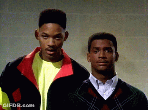 Two Men Standing Next To Each Other With One Wearing A Sweater GIF