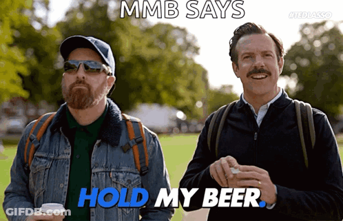 Two Men Standing Next To Each Other With The Words Mmb Says Hold My Beer GIF
