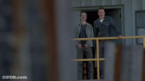 Two Men Standing On A Balcony With The Words " What About Me Rick " Above Them GIF