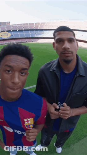Two Men Standing On A Soccer Field With One Wearing A Shirt That Says Sport GIF