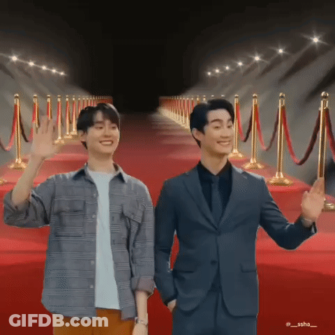 Two Men Standing On Red Carpet Waving GIF