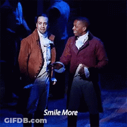 Two Men Standing On Stage Saying Smile More GIF