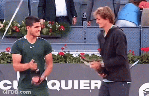 Two Men Standing On Tennis Court With Quier Sign GIF