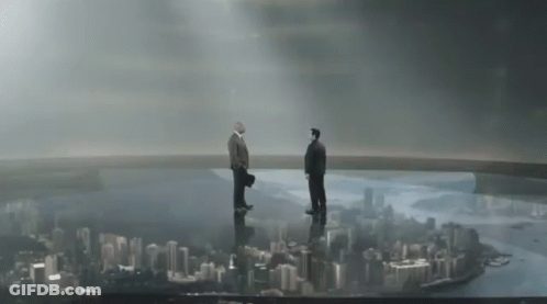 Two Men Standing On Top Of A Bridge Overlooking A City Skyline GIF