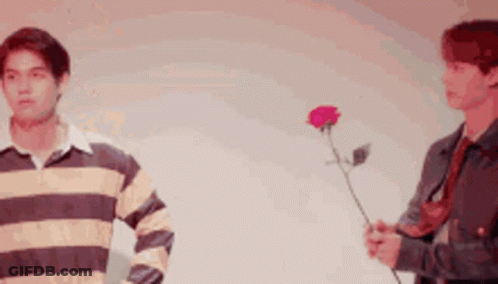 Two Men Standing One Holding Rose GIF