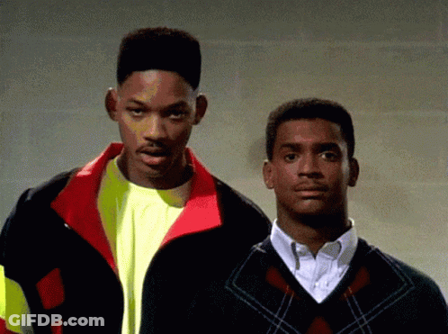 Two Men Standing, One In Sweater GIF