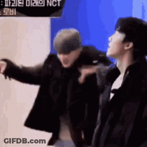 Two Men Standing, One Pointing At Camera GIF