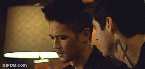 Two Men Standing, One With Neck Tattoo Saying X GIF
