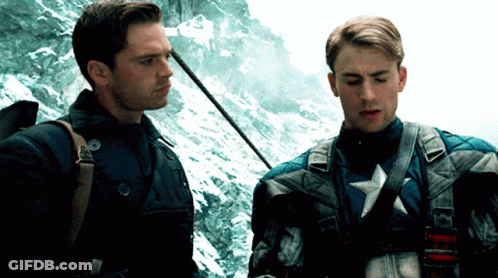 Two Men Standing One With Star On Chest GIF