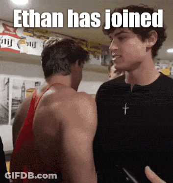 Two Men Standing With Ethan Has Joined Caption GIF