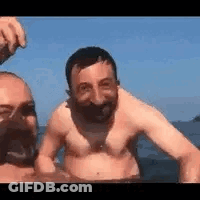 Two Men Swimming Shirtless In Ocean GIF