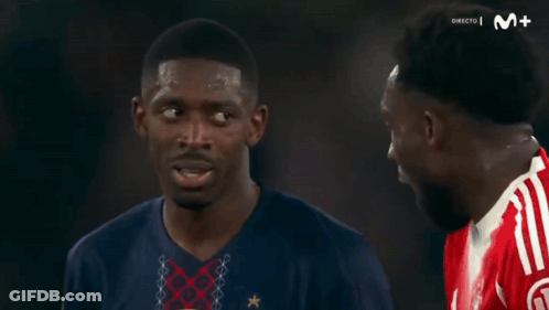 Two Men Talking Before Screen Saying Directo M + GIF