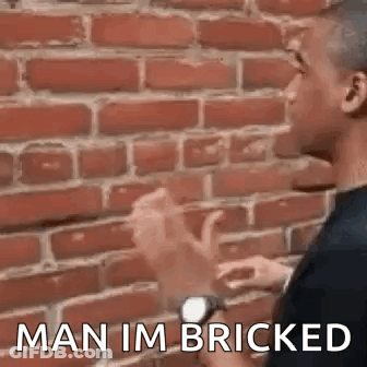 Two Men Talking By Brick Wall GIF