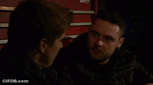 Two Men Talking In Dark Room By Red Toolbox GIF