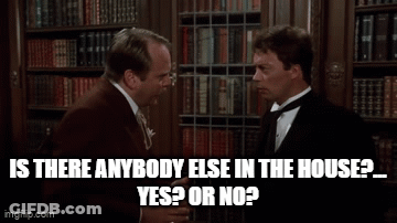 Two Men Talking In Front Of Bookshelf GIF