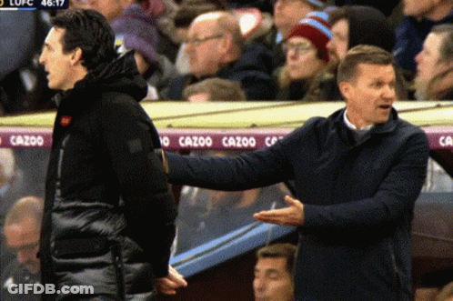 Two Men Talking In Front Of Cazoo Banner GIF