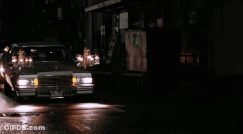 Two Men Talking In Front Of Dario M Sign GIF