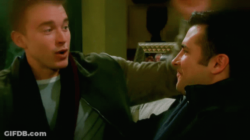 Two Men Talking In Front Of Framed Picture GIF