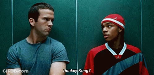 Two Men Talking Next To Green Wall GIF