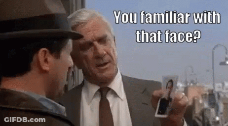Two Men Talking One Holding Picture Of Man GIF
