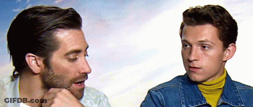 Two Men Talking One In Denim Jacket And Yellow Turtleneck GIF
