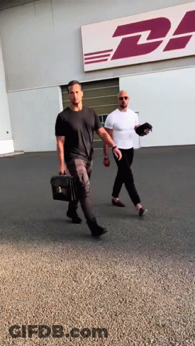 Two Men Walking In Front Of DHL Building GIF