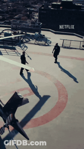 Two Men Walking On Roof With Netflix Logo GIF
