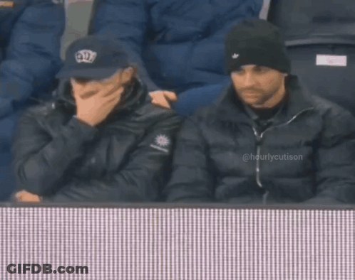Two Men Watching Game Man In Crown Hat GIF