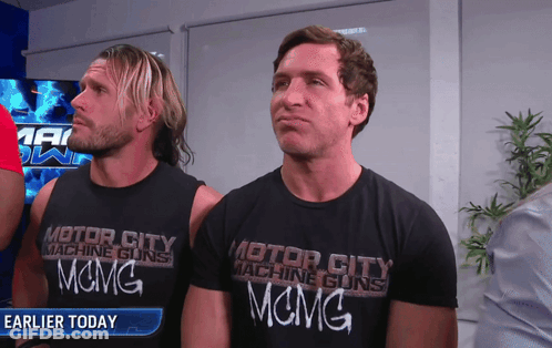 Two Men Wearing Black Motor City Machine Guns Shirts GIF
