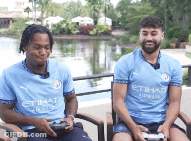 Two Men Wearing Etihad Airways Shirts Sit In Chairs GIF