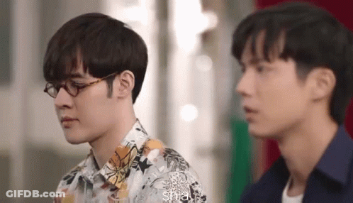 Two Men Wearing Glasses Are Standing Next To Each Other And Looking At Each Other . GIF
