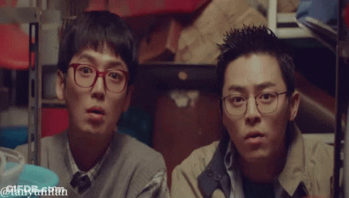 Two Men Wearing Glasses Are Standing Next To Each Other In A Room With The Words Fanyunifan Below Them GIF