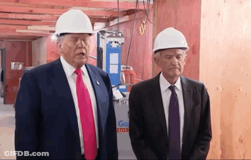 Two Men Wearing Hard Hats Are Standing In Front Of A Sign That Says Go 2703 GIF
