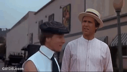Two Men Wearing Hats And Ties Are Standing Next To Each Other On A City Street . GIF