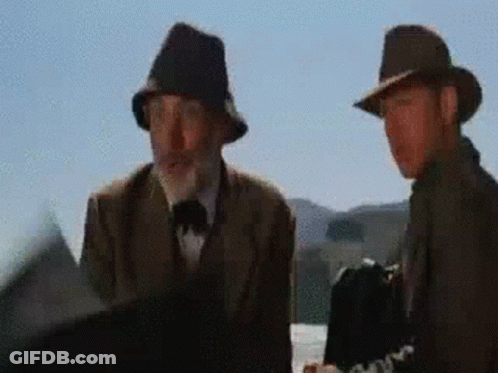 Two Men Wearing Hats Are Standing Next To Each Other And Talking GIF